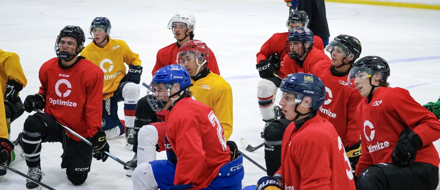 Un groupe de joueurs à genoux sur la glace pendant un événement Optimize